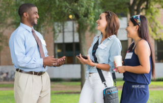 a teenage girl and her mother tour a college campus with a man tour guide
