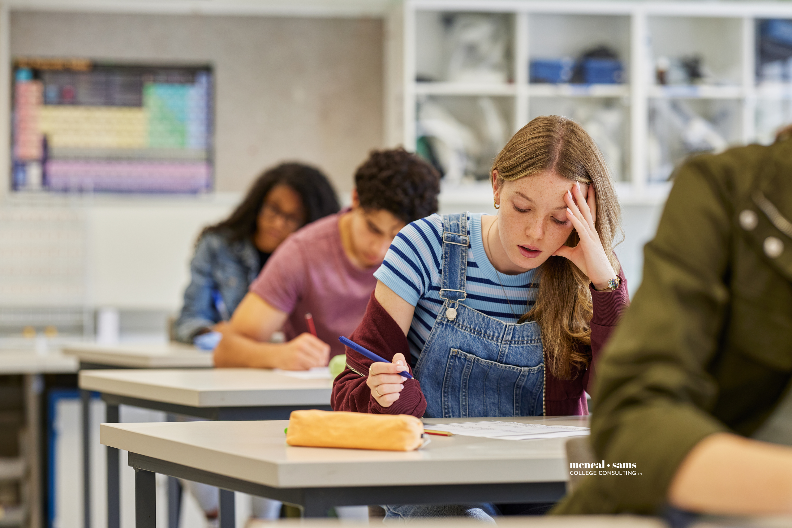 high school students seated at desks in a classroom taking a test