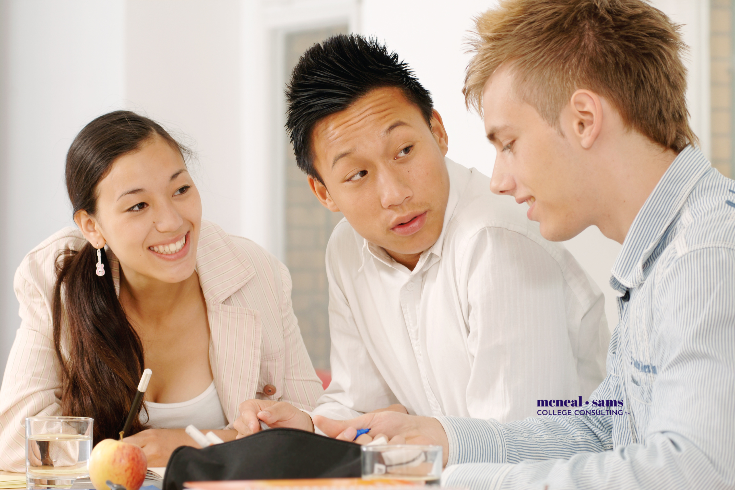A young woman and two young men collaborate in a professional workspace